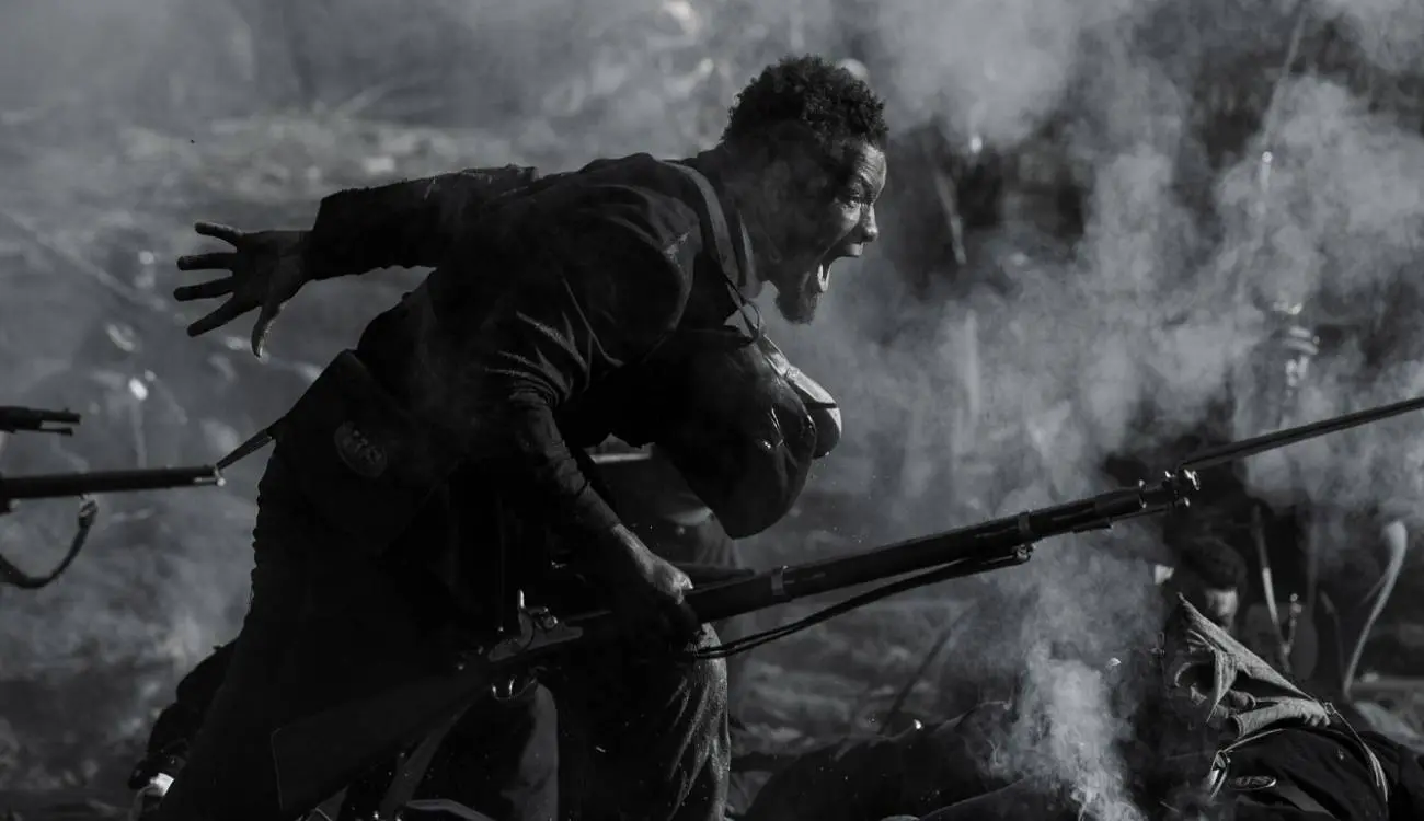 An enslaved Black man running on the battlefield fighting for his freedom 